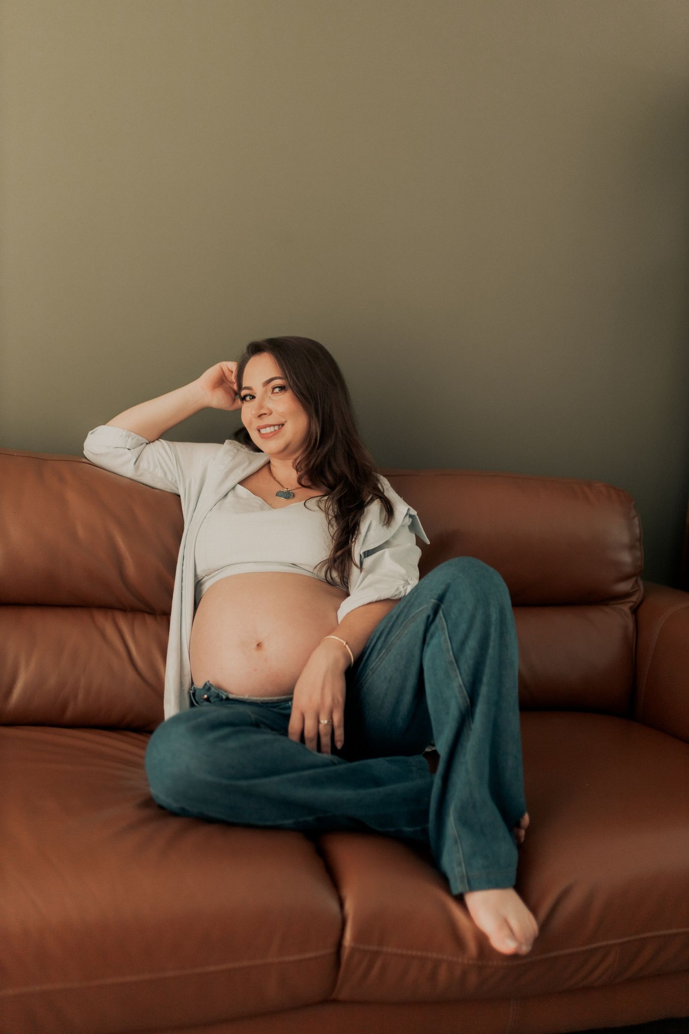 Future maman se reposant sur un canapé confortable pendant sa grossesse