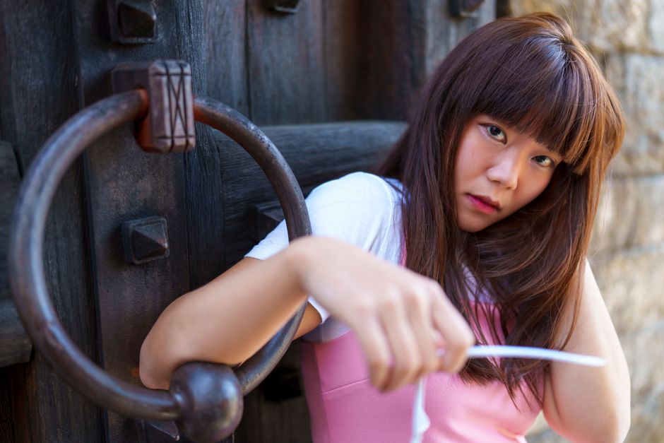 Portrait of a young woman with a serious expression by a large rustic door knocker in Calistoga, California.