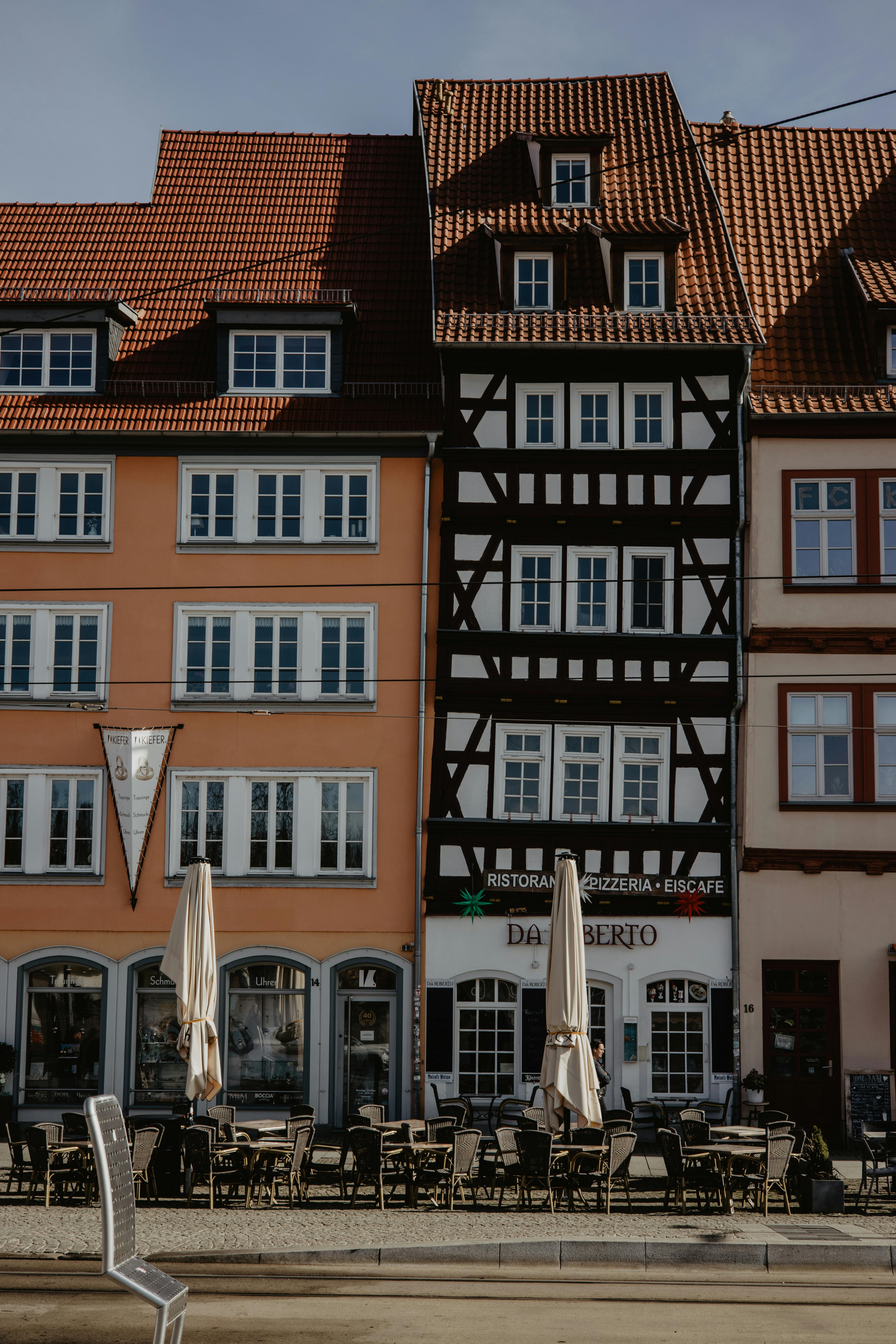 бесплатная Очаровательные фахверковые здания в Эрфурте, Германия, с уличными кафе. Стоковое фото