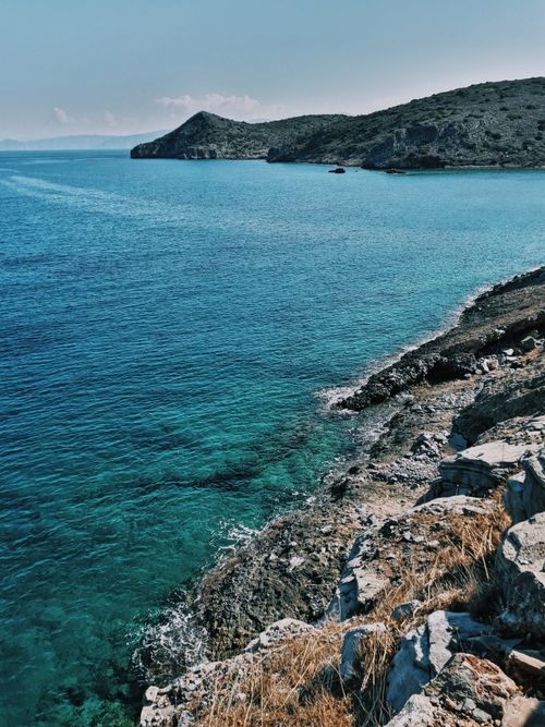 Free Peaceful coastal scene featuring blue waters and rugged cliffs. Perfect for nature lovers. Stock Photo