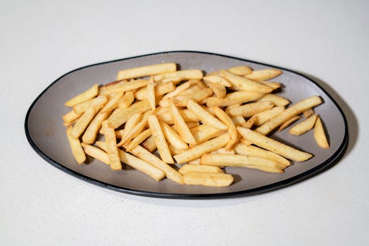 A plate filled with freshly cooked crispy golden French fries. Perfect snack or side dish.