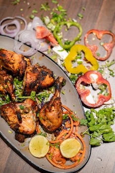 Savor the vibrant flavors of tandoori chicken with fresh vegetables, perfect for food photography enthusiasts.