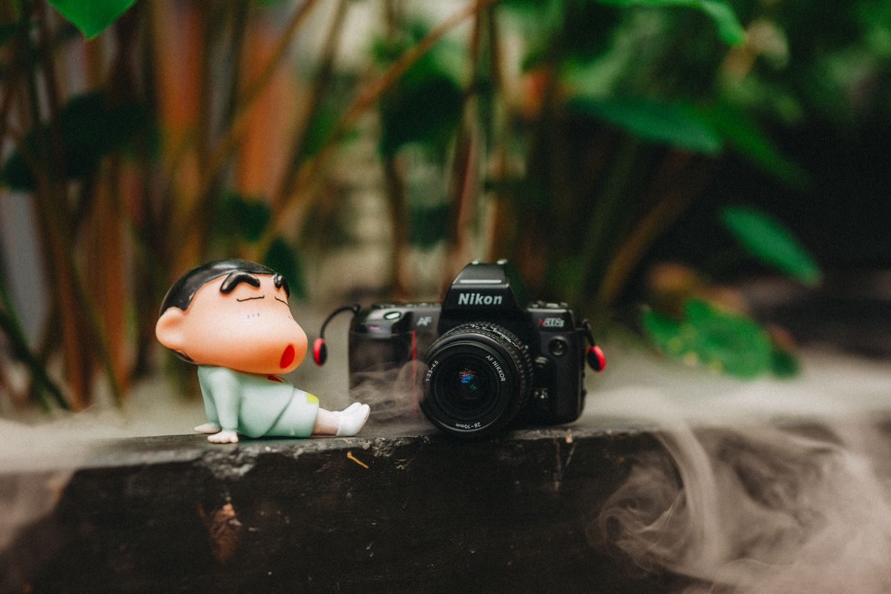 charming scene with a playful figurine next to a vintage camera amidst