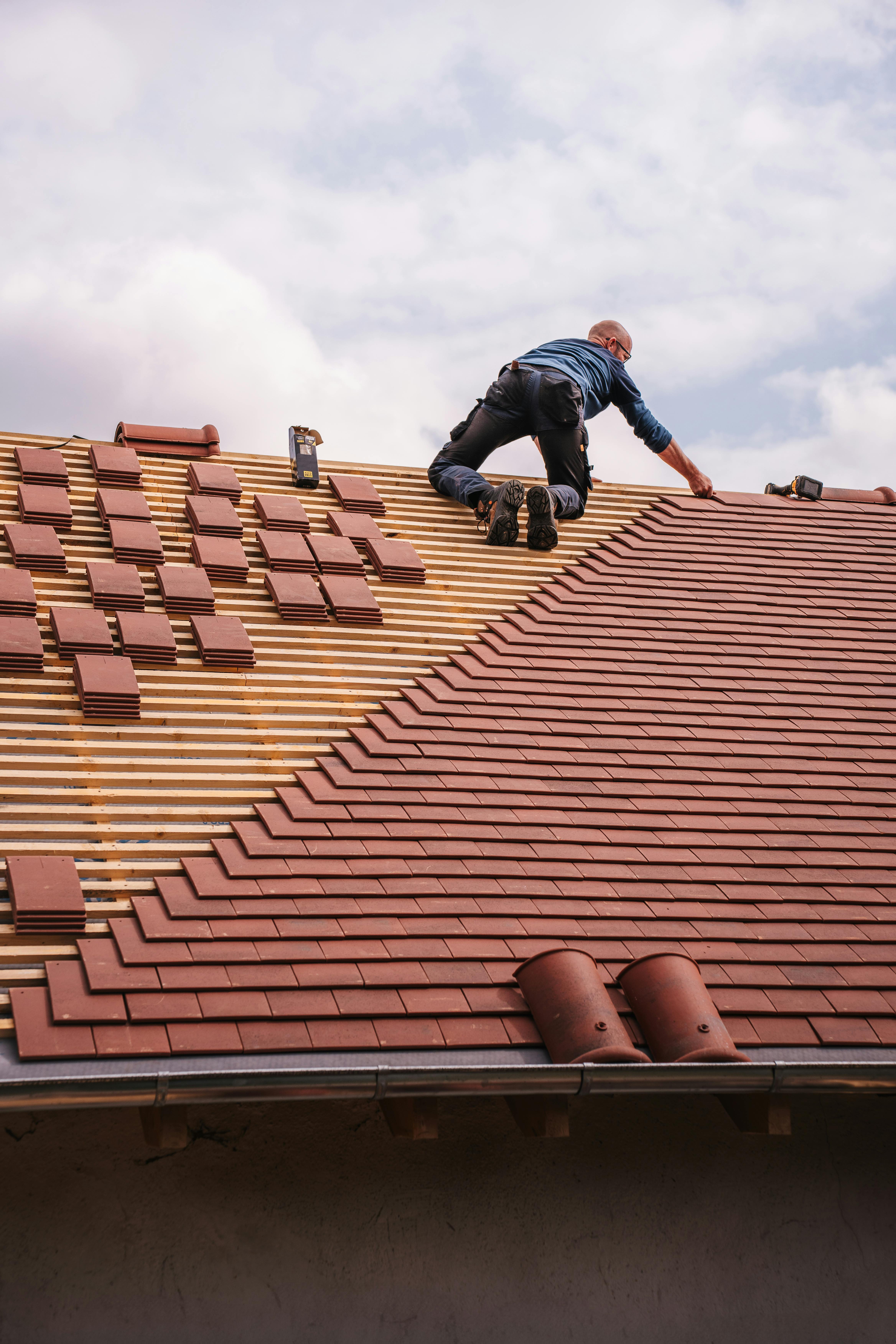 A man is working on the roof of a house.