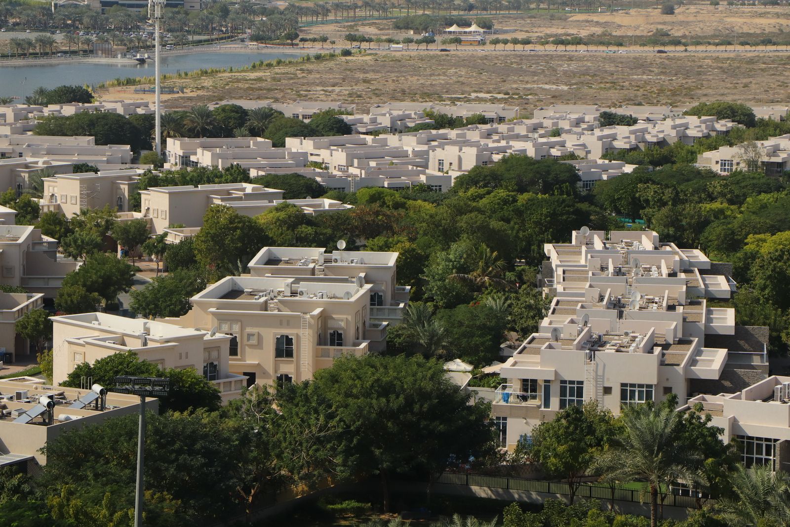 Aerial view of a low-rise Dubai residential community beside a lake