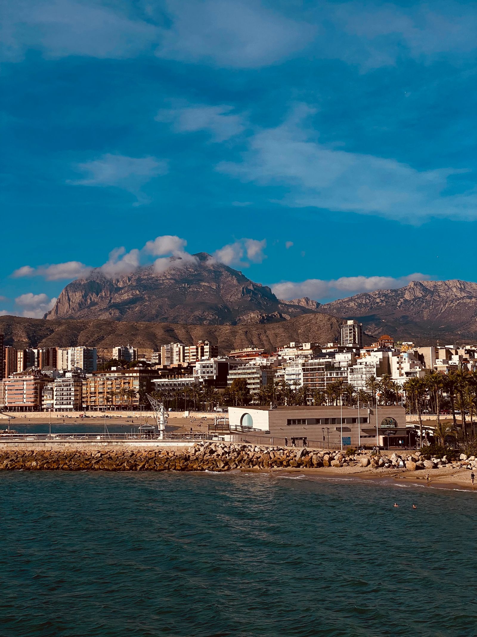 Cazare în Benidorm: plaja și blocurile orașului, cu munții Costa Blanca în spate