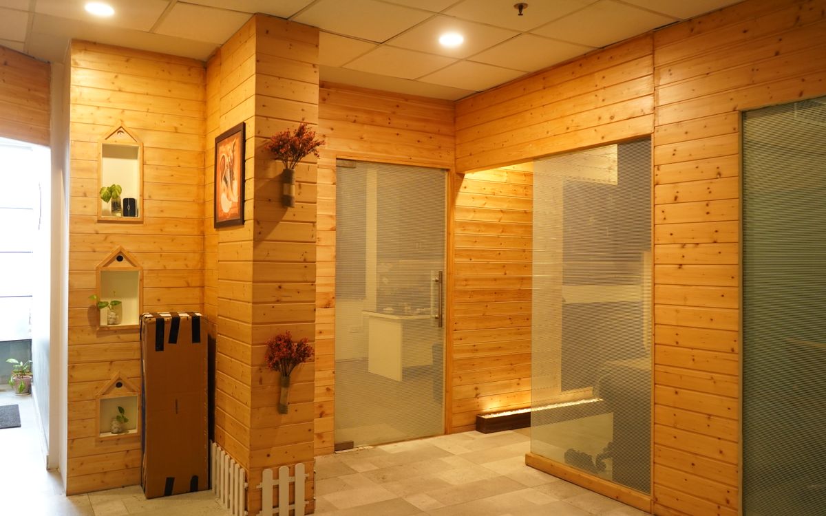 Warm office interior with wooden wall panels, soft lighting and modern glass doors