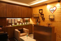 A modern and cozy reception area with wooden decor, indoor plants, and soft lighting.
