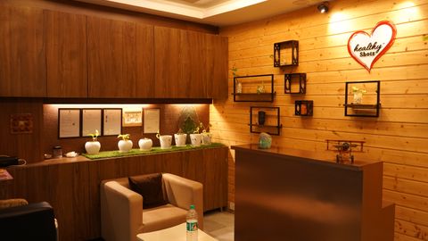 A modern and cozy reception area with wooden decor, indoor plants, and soft lighting.