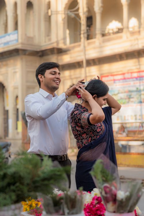 Free Joyful couple sharing a tender moment surrounded by vibrant flowers in an outdoor market. Stock Photo