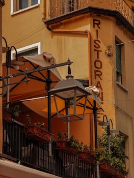 Close-up of a traditional Italian restaurant facade with vibrant colors and vintage lighting.