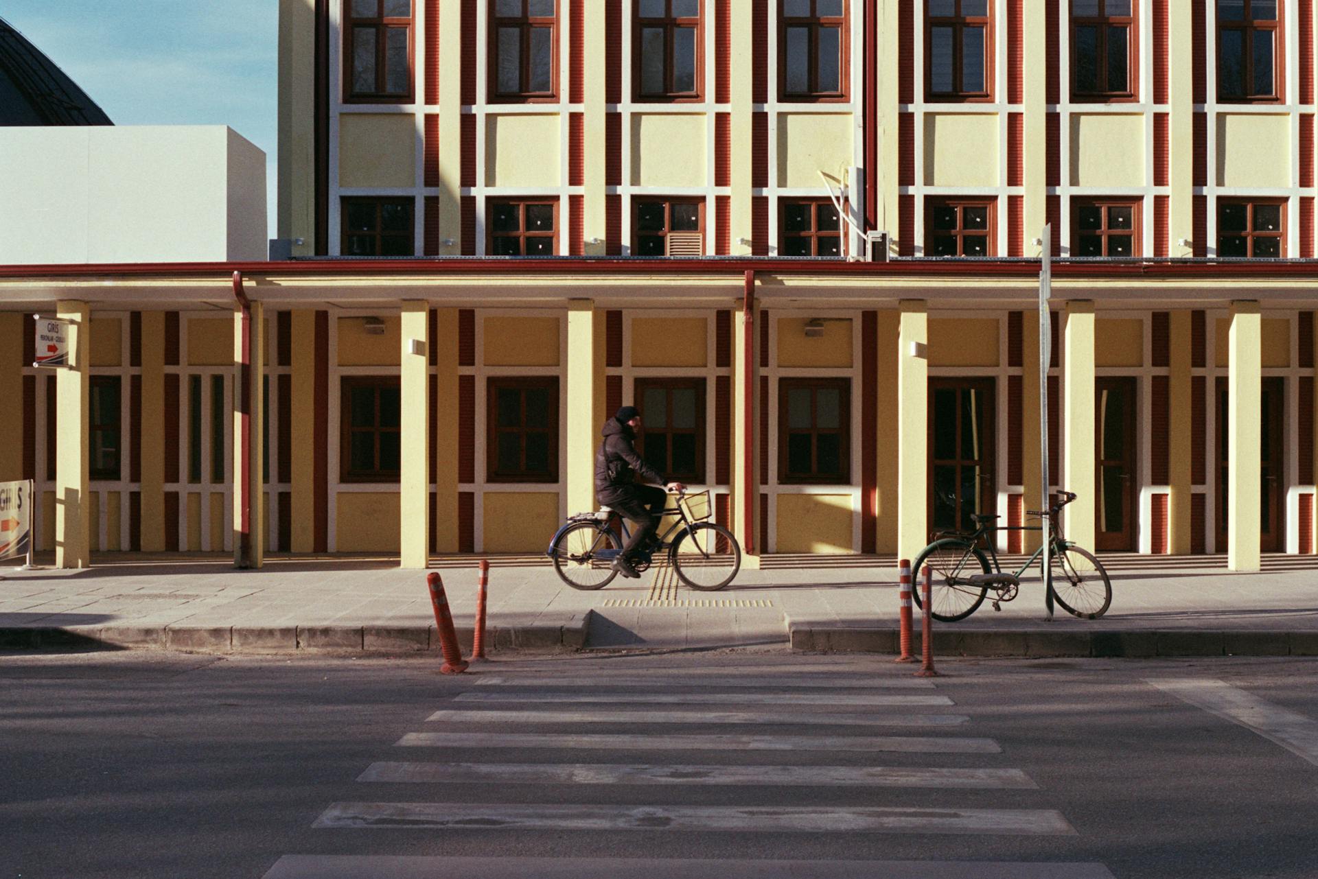 a Man riding a bike in front of the building