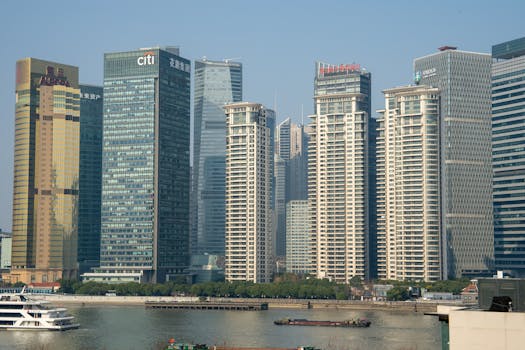 Sunlit view of Pudong's modern skyscrapers across the Huangpu River in Shanghai.
