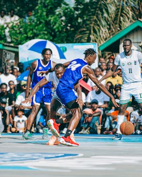 Vibrant street basketball scene with players in intense action and a lively crowd.