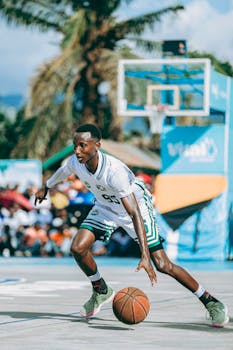 Young athlete dribbling basketball in outdoor game, vibrant and energetic setting.