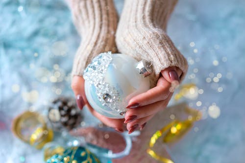 Person Holding White Bauble 