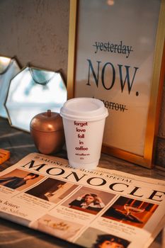 Elegant coffee bar setup with decorative elements, magazine, and motivational sign.