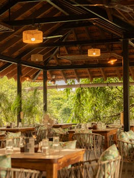 Rustic restaurant with wooden tables and lush greenery in Anjuna, Goa.