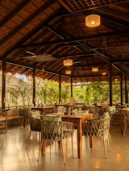 Rustic open-air dining area with greenery and wooden decor in Anjuna, Goa.