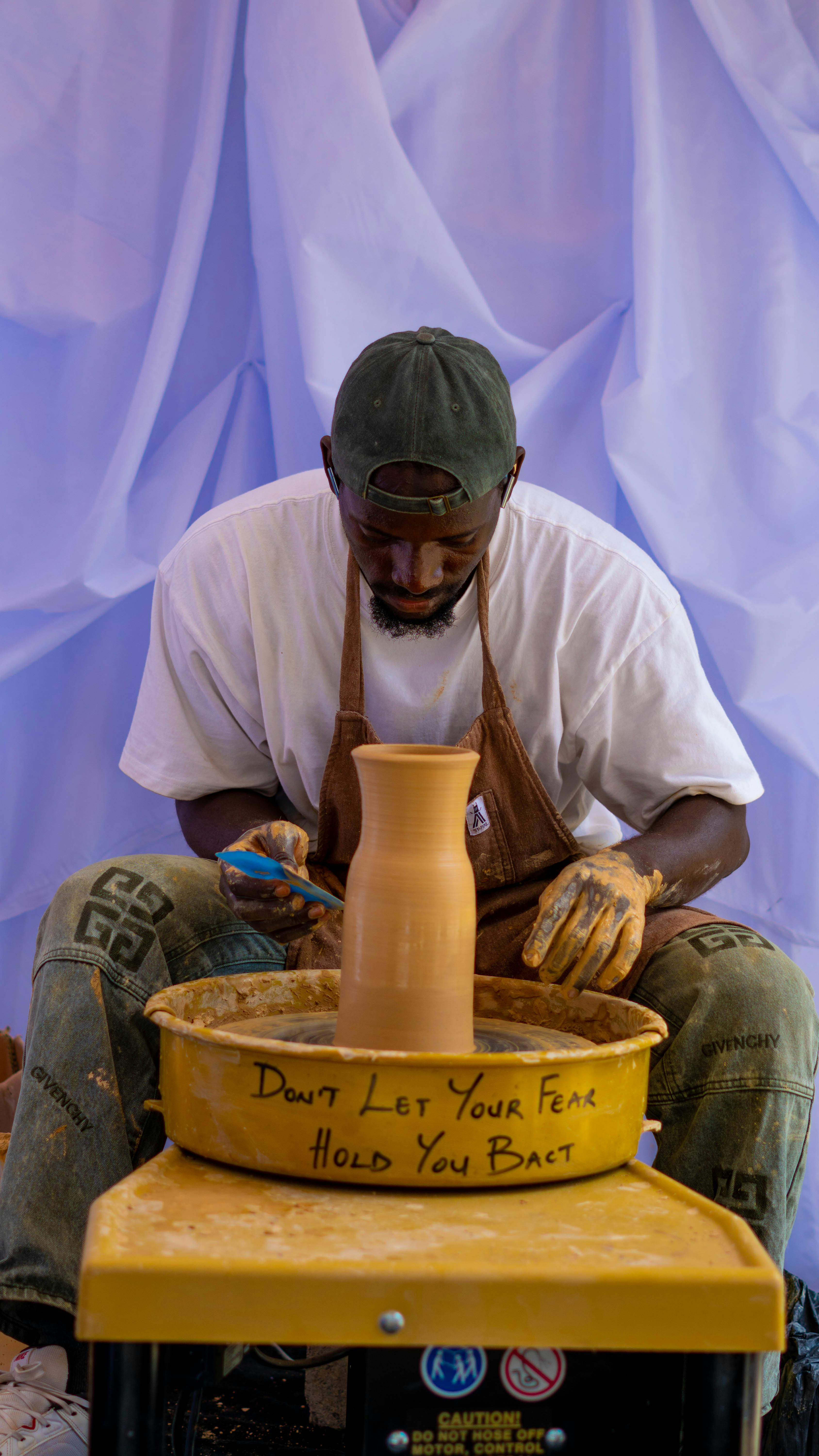 A focused artisan crafts pottery on a wheel, embodying creativity and tradition.