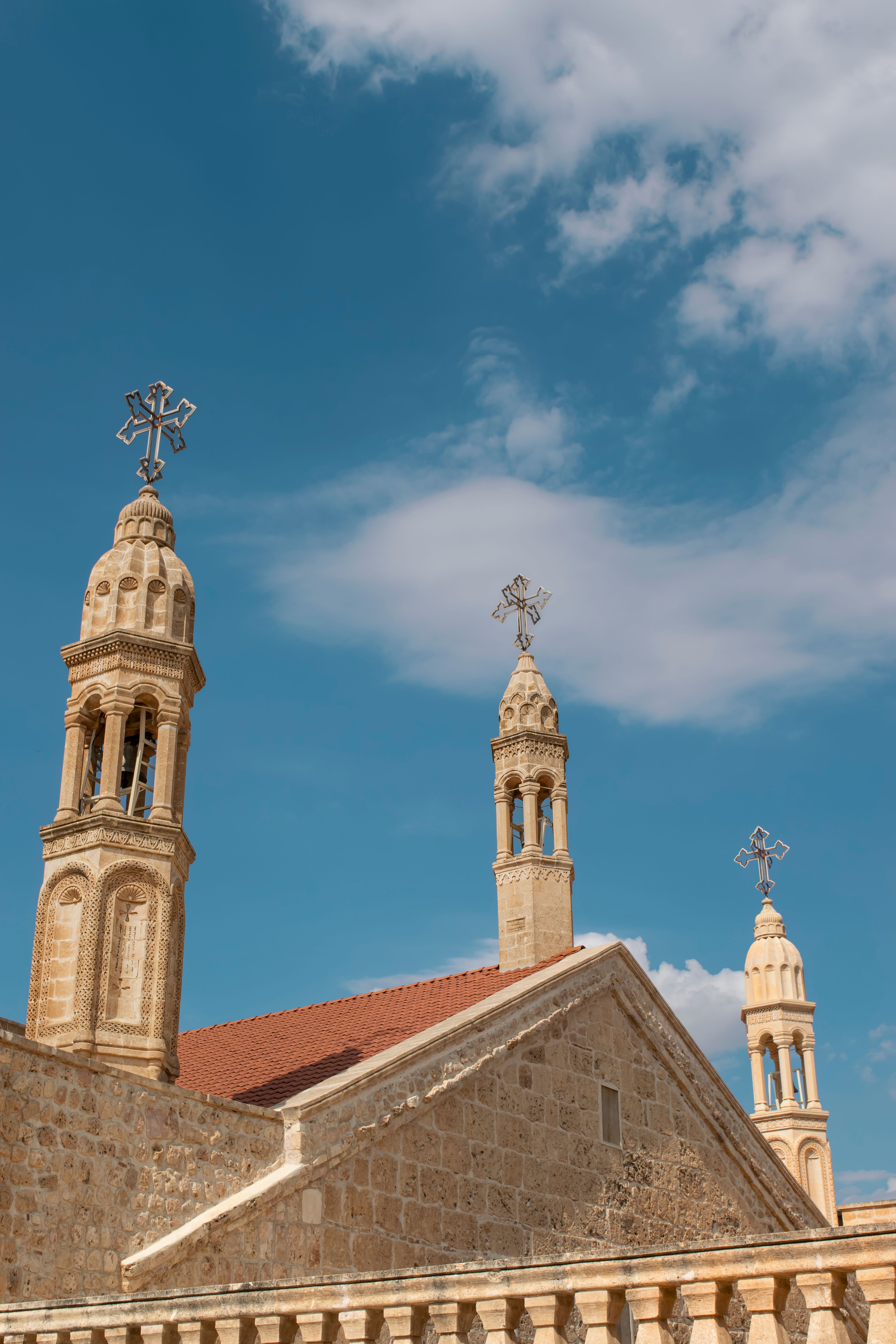 Old stone church towers with crosses under a blue sky.