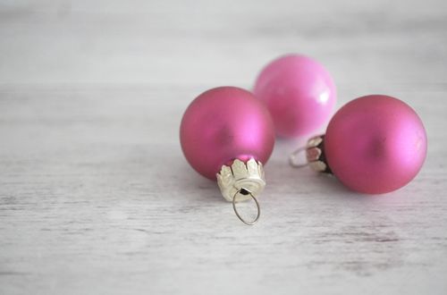 Free Minimalist image of pink Christmas ornaments on a light wooden background, perfect for holiday themes. Stock Photo