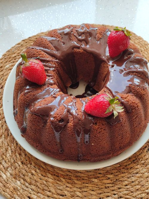Free Close-up of a chocolate bundt cake topped with fresh strawberries and chocolate glaze. Stock Photo
