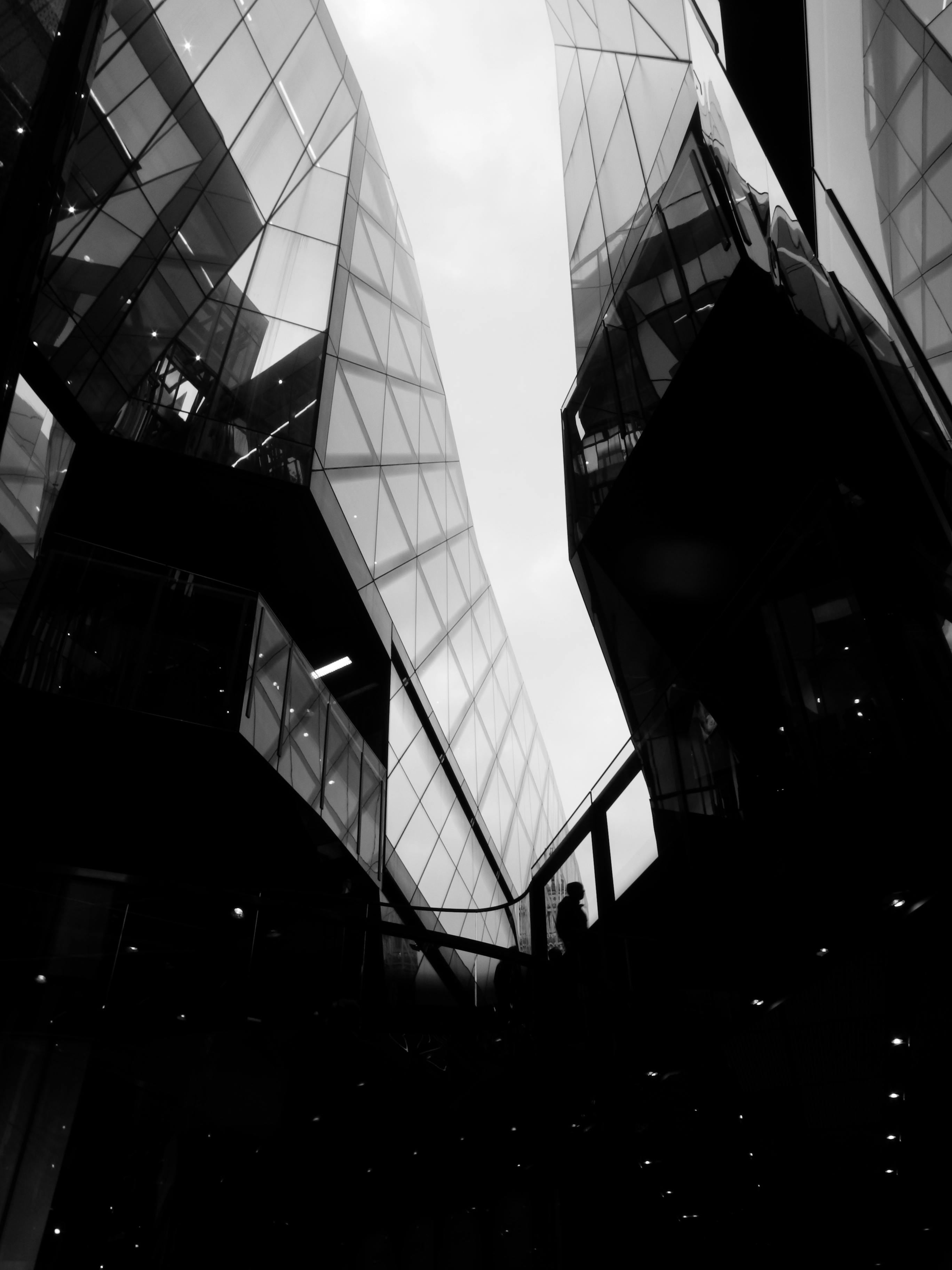 Stunning black and white shot of modern architecture in London, capturing a silhouette amidst towering glass structures.