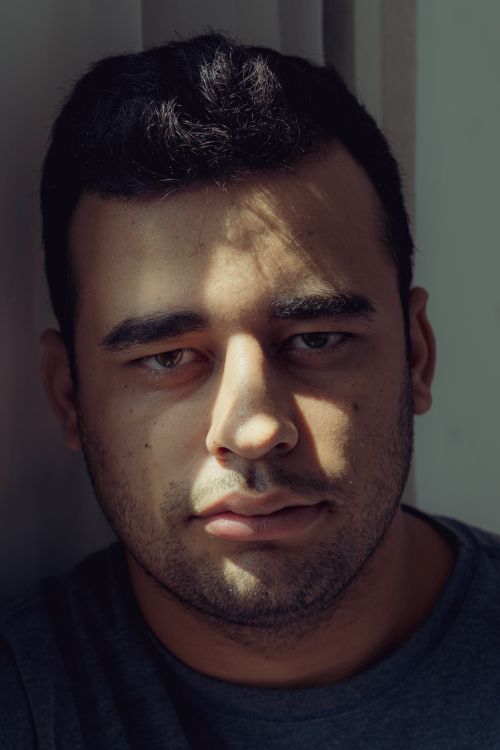 Free A contemplative adult male in soft natural light, evoking thoughtful introspection. Stock Photo
