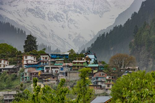 Free Scenic view of a colorful village in Manali with the snowy Himalayas in the background. Stock Photo