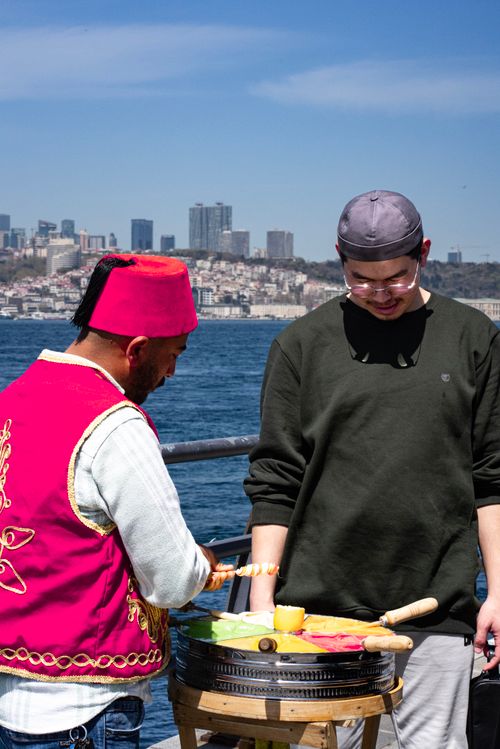 Free A street vendor prepares colorful Turkish candy by the Bosphorus in Istanbul with a scenic city backdrop. Stock Photo