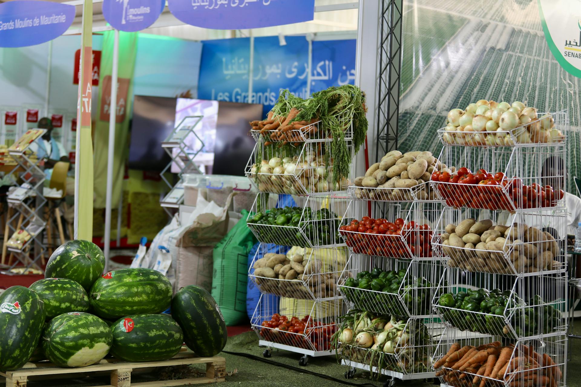 Vibrant market stall displaying watermelons, carrots, and more fresh produce.