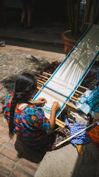 A woman weaves vibrant textiles outdoors in Antigua Guatemala.