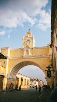 The iconic Arco de Santa Catalina in vibrant Antigua, Guatemala on a sunny day, showcasing cultural heritage.