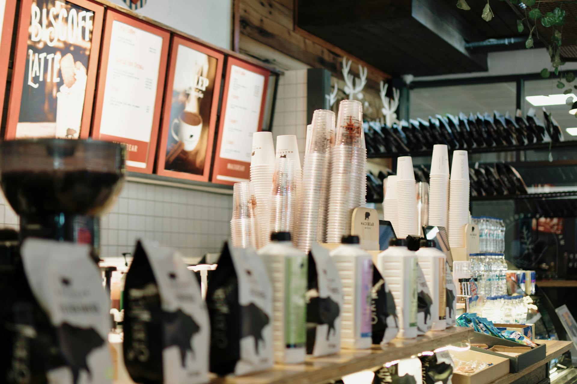 Interior view of a coffee shop with stacked cups and varied coffee supplies on display.