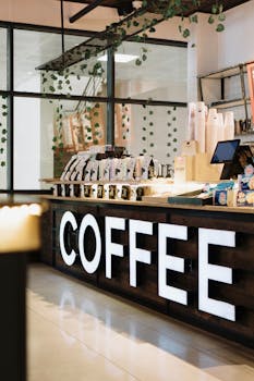 Interior of a modern coffee shop featuring a display counter with coffee bags and accessories.