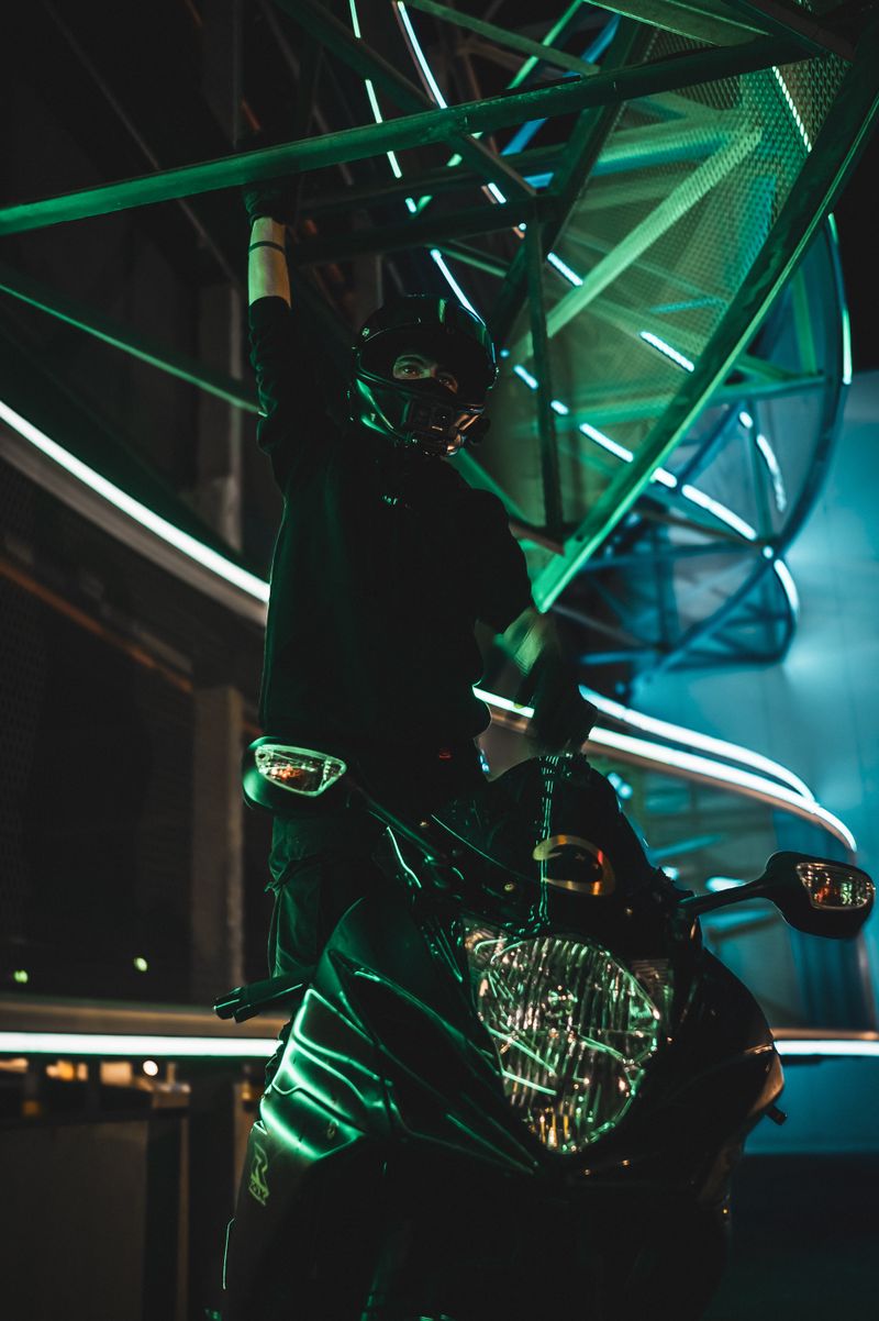 A daring motorcyclist performs a stunt under vibrant neon lights