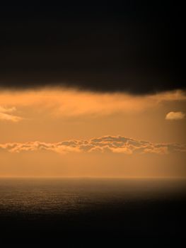 Captivating sunrise over the ocean with dramatic golden clouds creating a stunning horizon.