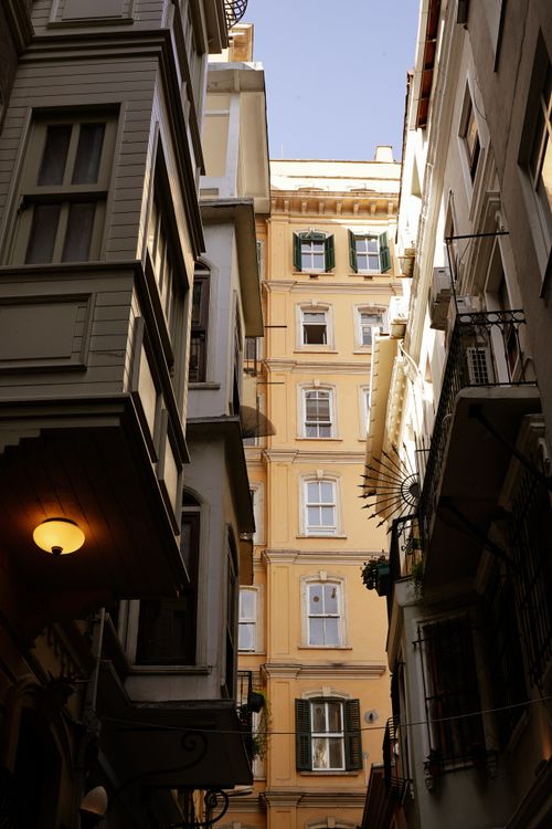 Free Sunlight illuminating historic buildings in a narrow alleyway, creating a moody urban scene. Stock Photo