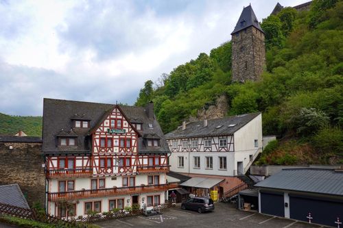 Free Picturesque medieval village with half-timbered houses and a historic tower amidst lush greenery. Stock Photo