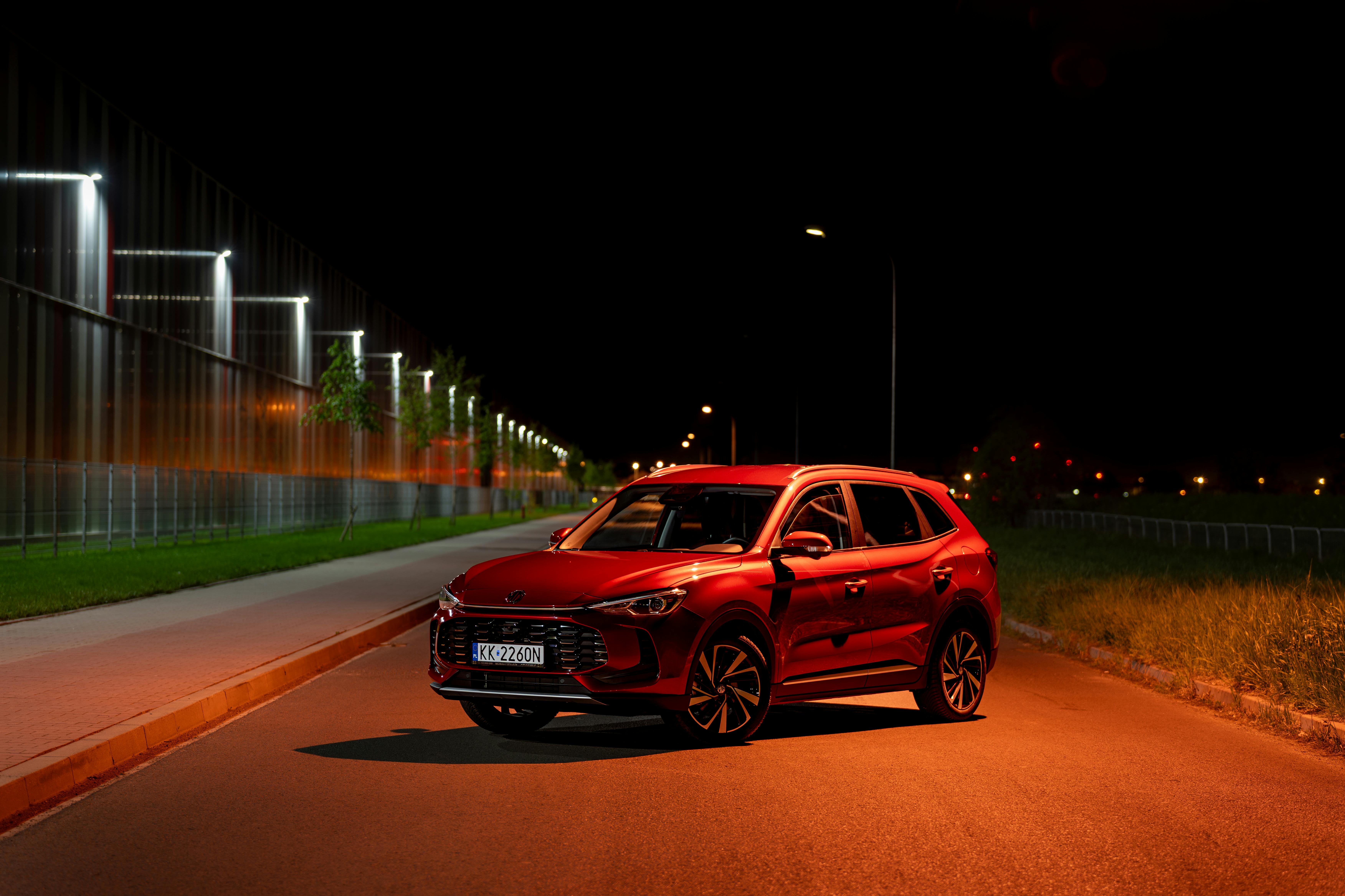 Free Red SUV illuminated by streetlights at night in Kokotów, Poland. Modern urban vibe. Stock Photo
