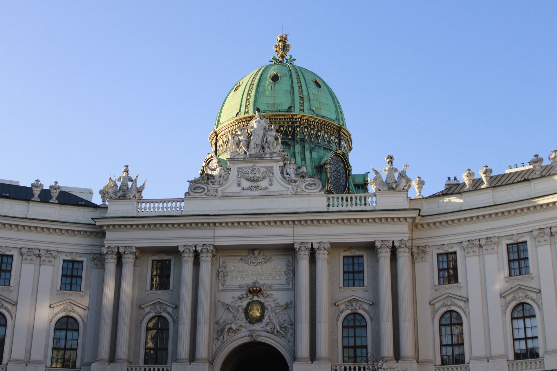 Stunning architectural view of Hofburg Palace with a green dome in Vienna, Austria.