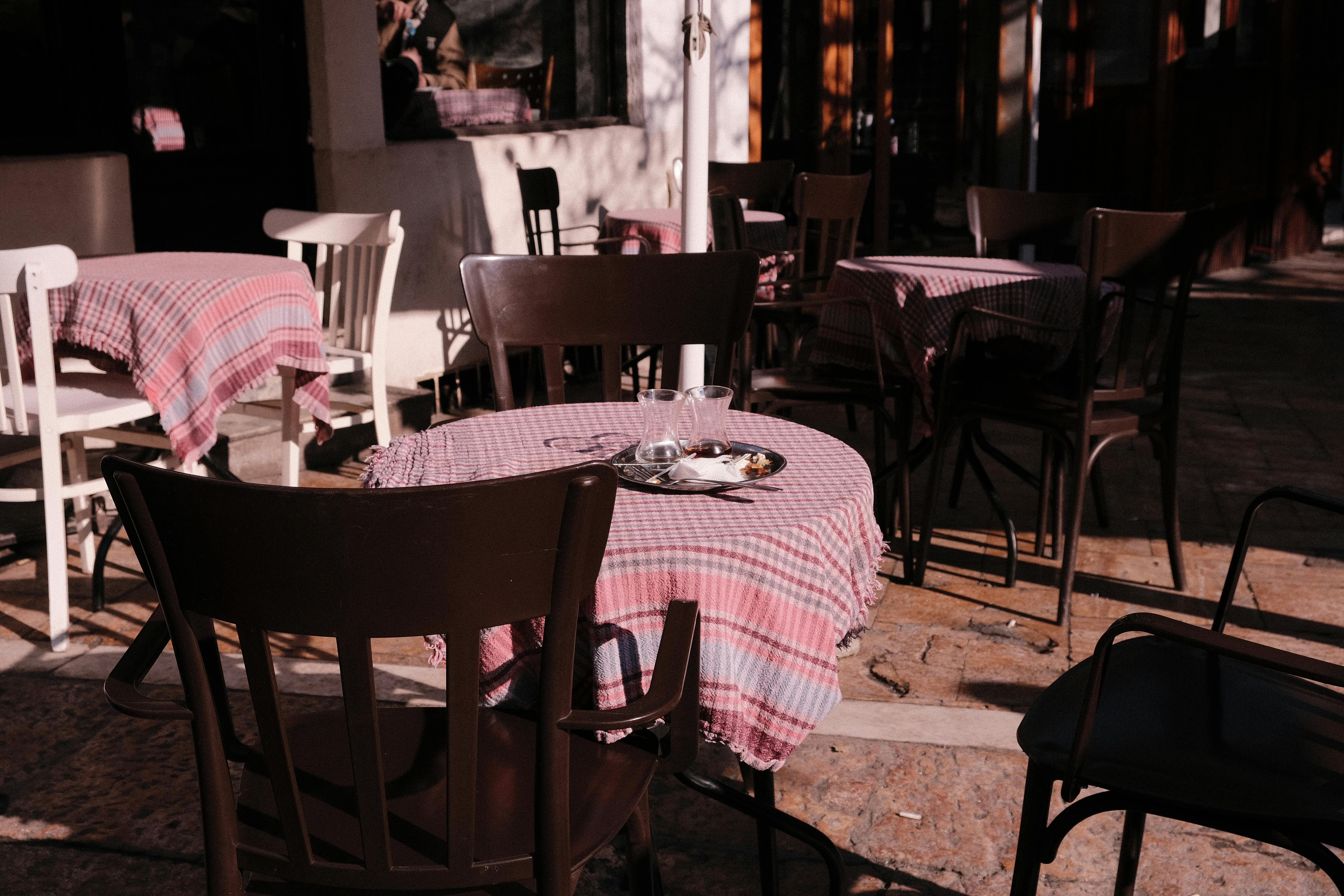 Gratuit Cafenea fermecătoare în aer liber din Skopje, cu băuturi pe o masă în carouri roz, la lumina zilei. Fotografie de stoc