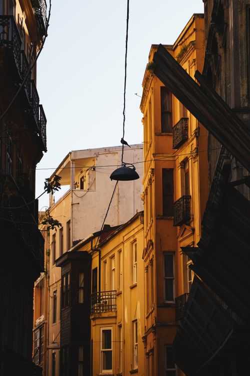 Free Warm sunlight on historic European alley with vibrant architecture. Stock Photo