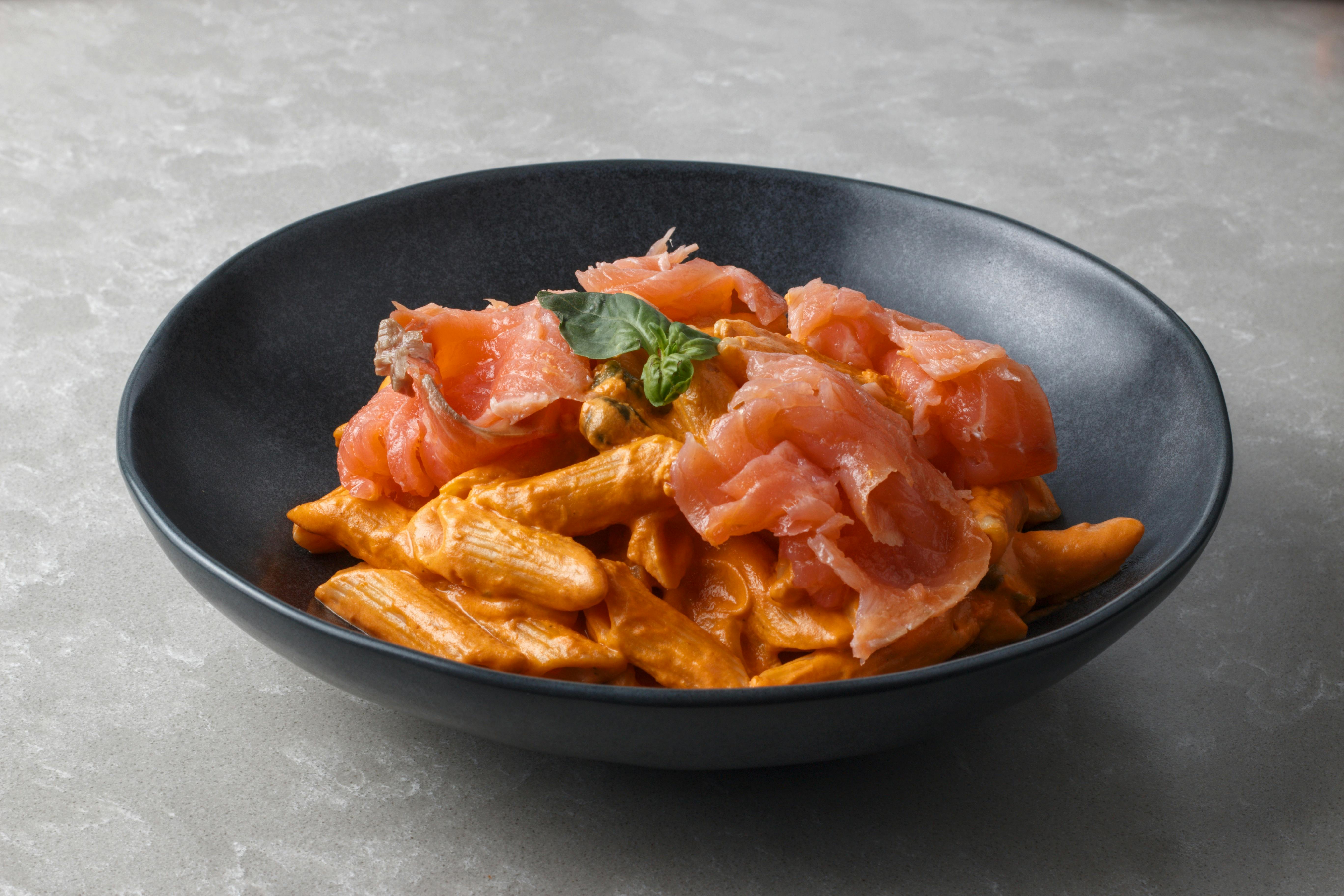 Een kom romige pasta met zalm