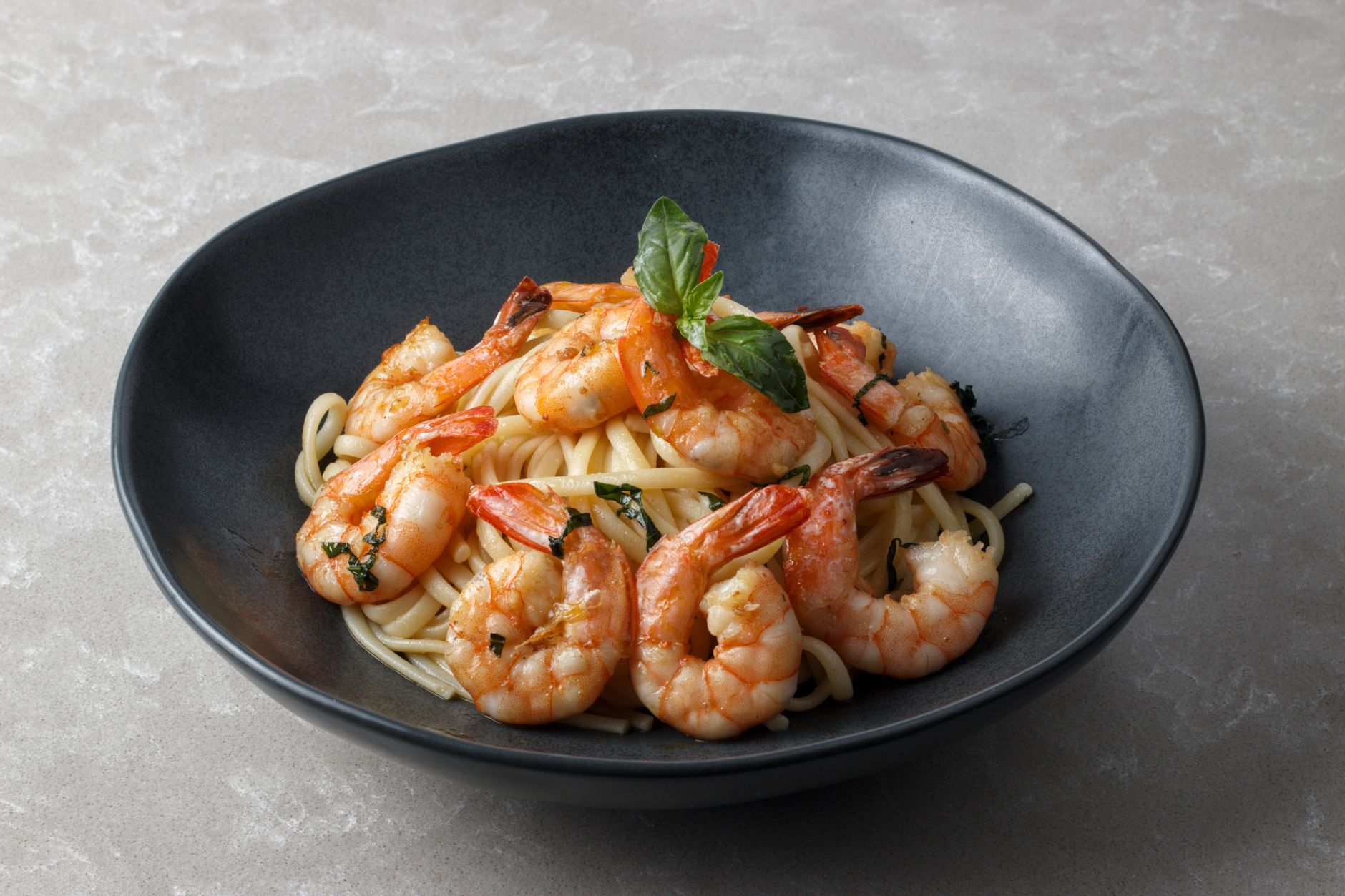 Close up of sautéed shrimp in a skillet with garlic and herbs