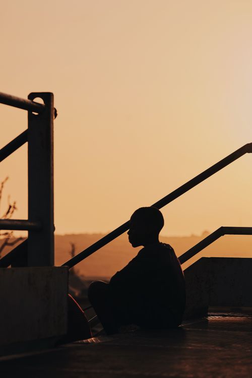 Free Silhouette of a person sitting on a staircase during sunset in Jos, Nigeria. Stock Photo