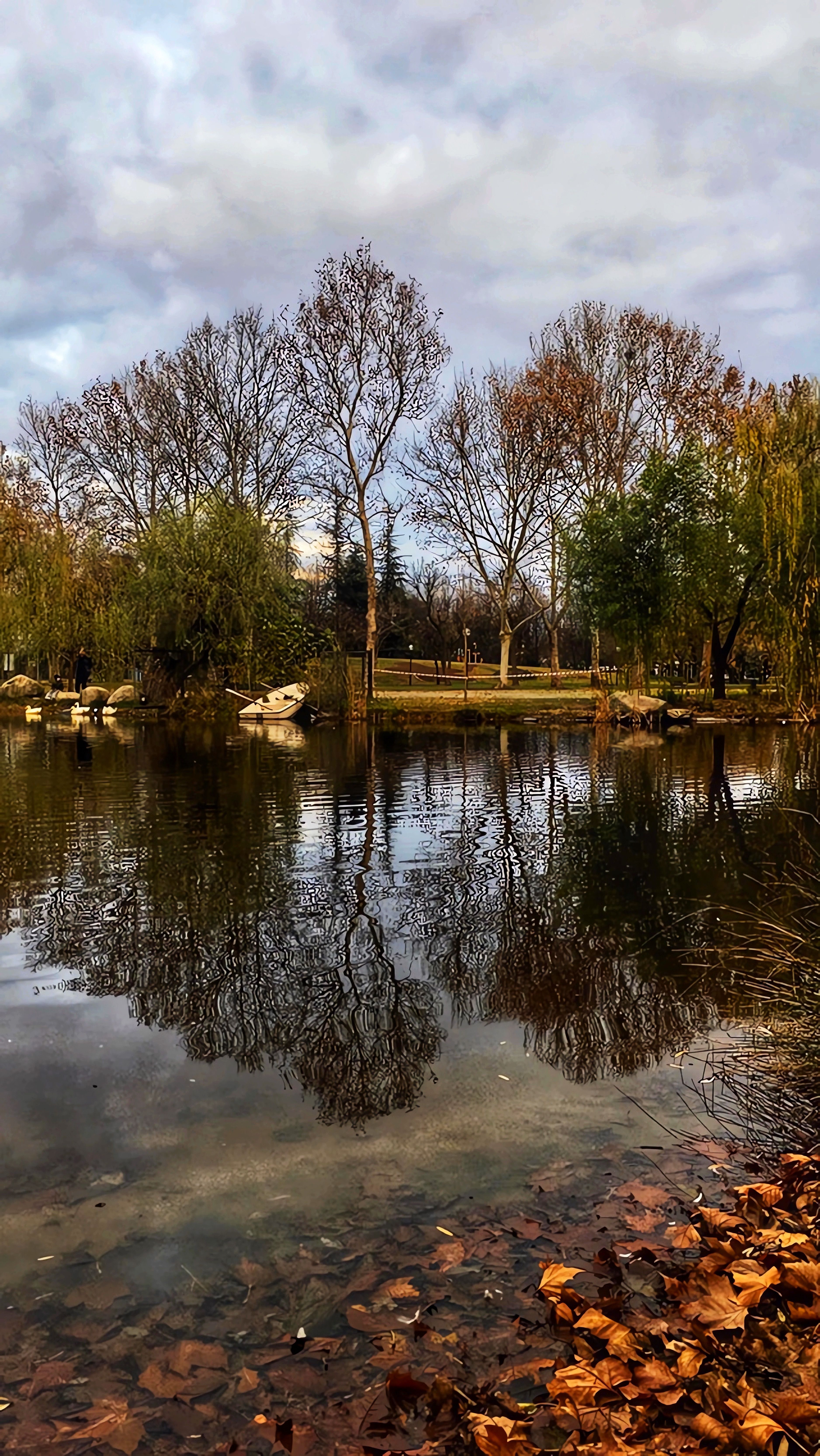 Calm autumn scene with tree reflections in a tranquil lake at Bursa, Türkiye park.