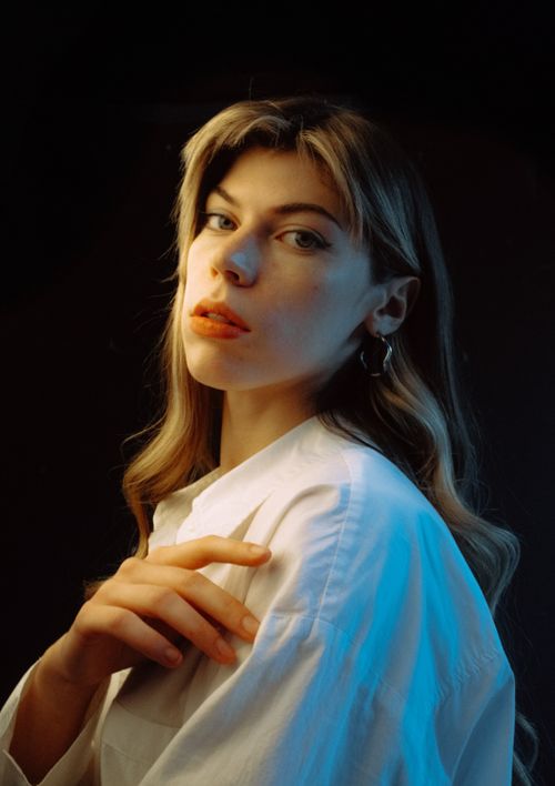 Free A striking portrait of a young woman with dramatic lighting and a stylish pose. Stock Photo