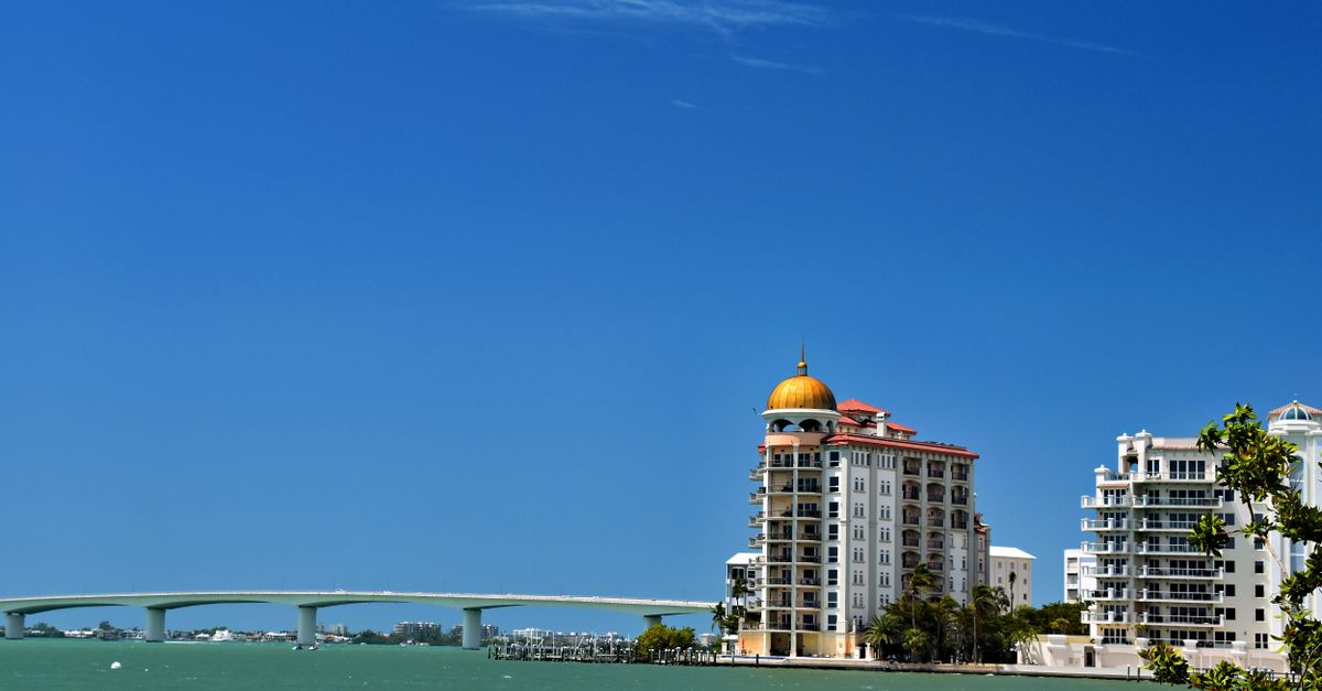 Stunning waterfront view of Sarasota's skyline and bridge under a clear blue sky.